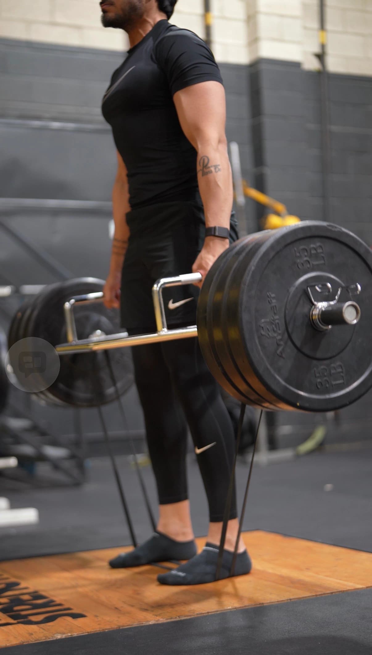 Coaching focus on execution — how each rep is performed, not just whether it gets done. Athlete performing a heavy trap-bar deadlift with controlled execution under coaching supervision